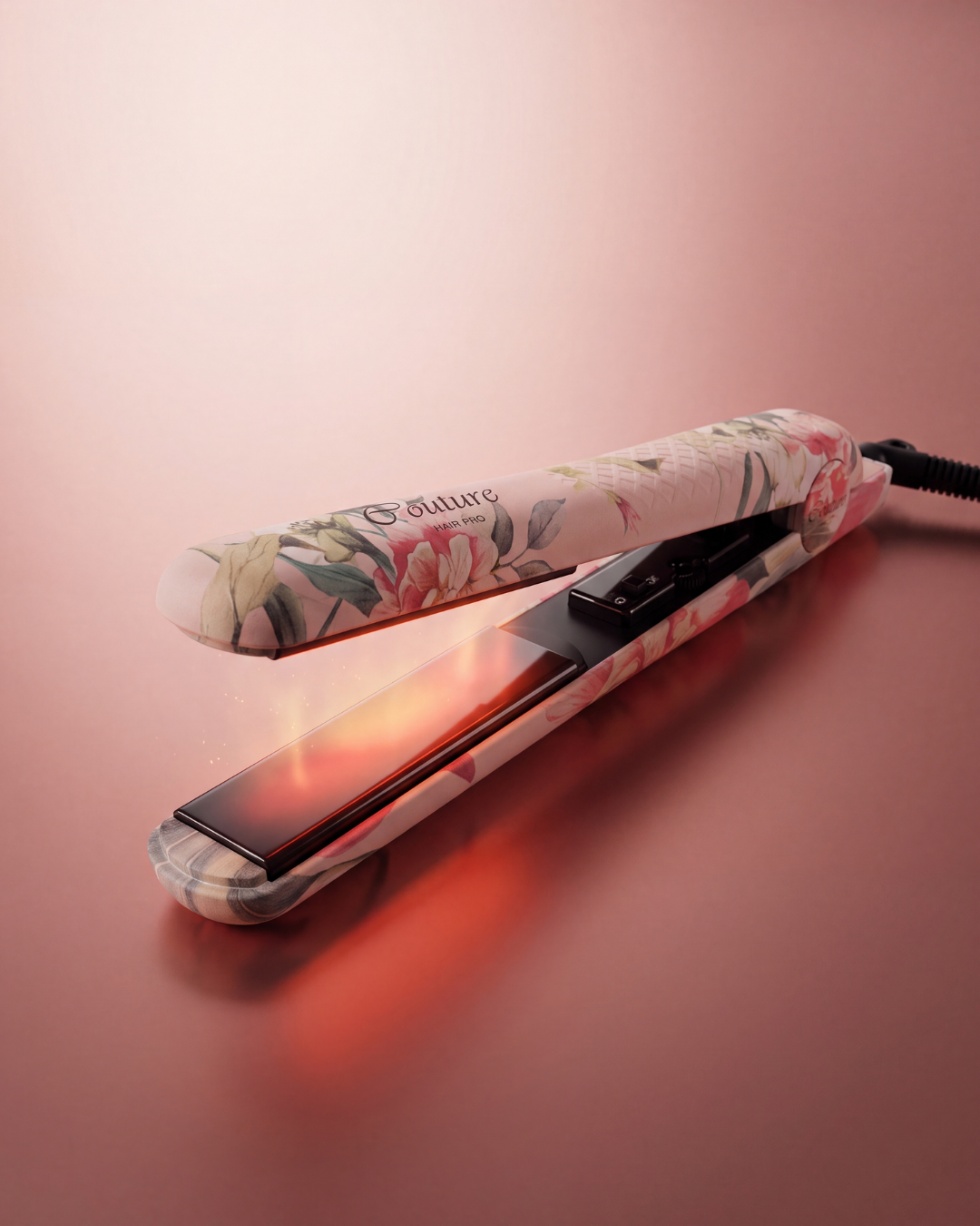 A hair straightener with a pink and white floral pattern, shown open with its heating plates glowing red. The brand name 'G future' is printed on the upper plate.